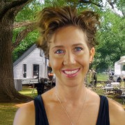 Smiling woman with short dark hair, wearing a black tank top